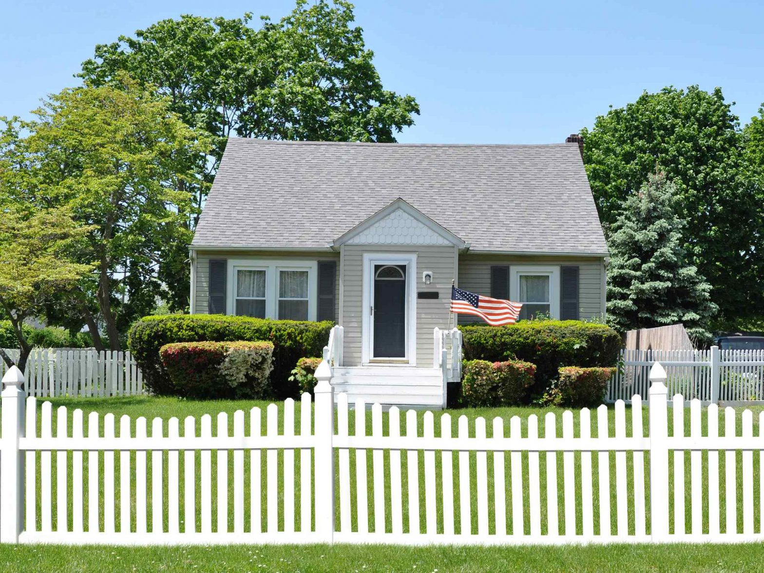 Photo of a vinyl picket fence in front of a residence